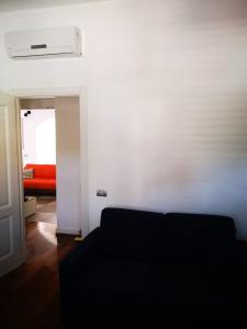 un soggiorno con divano e letto rosso di Central apartment a Civitavecchia