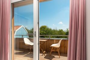 a balcony with a view of a table and chairs at B&B Duinblick in De Koog