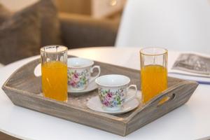 two glasses of orange juice and two cups on a tray at Pargas Dream in Parga