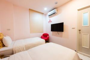 Habitación con 2 camas y TV de pantalla plana. en Start Hotel en Kaohsiung