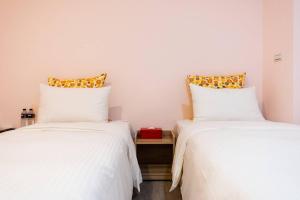 dos camas sentadas una al lado de la otra en una habitación en Start Hotel en Kaohsiung