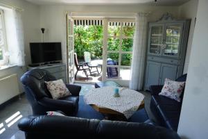 a living room with two couches and a table at Günnis Perle am Harleufer in Carolinensiel