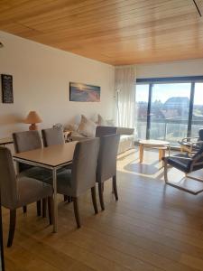 a living room with a table and chairs and a couch at Appartement en bord de mer avec piscine intérieure in Oostduinkerke-Bad