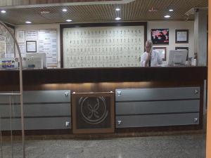 a man standing at the counter of a restaurant at Grande Hotel Universo Palace in Uberlândia