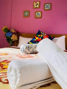 a bed with towels on it with a pink wall at Lisbon Prime Hostel & Rooms in Lisbon
