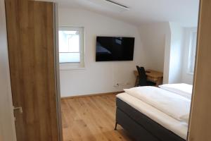 a bedroom with a bed and a television on the wall at Apartment DreamView in Drobollach am Faakersee
