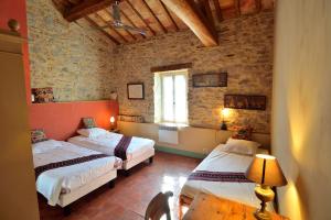 een kamer met 2 bedden en een raam in een gebouw bij Le village-hôtes in Sainte-Vallière