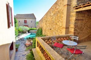 un patio con mesa y sillas junto a un edificio en Le village-hôtes, en Sainte-Vallière