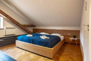 a bedroom with a bed with a blue comforter at Old Town Square Suites Prague in Prague