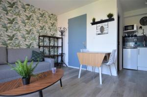 uma sala de estar com um sofá e uma mesa em Appartement, duplex à 500m de la mer avec balcon em Courseulles-sur-Mer