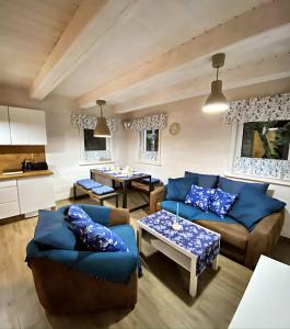 a living room with blue couches and a table at Anielska Chatka Istebna in Istebna +28 photos