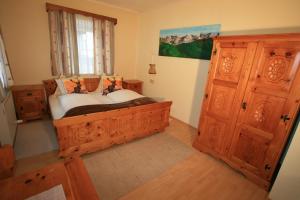 ein Schlafzimmer mit einem Holzbett und einem Fenster in der Unterkunft Hotel Stadlwirt in Rangersdorf