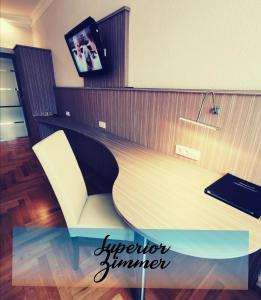 a desk with a chair and a tv in a room at Hotel Goldener Anker in Torgau