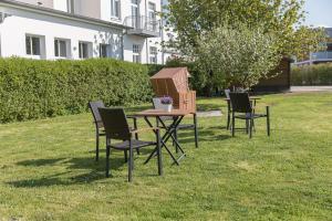 a table with chairs and a bird house on the grass at Villa Vineta in Kühlungsborn