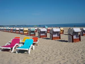 een rij strandstoelen en hutten op het strand bij Hotel Polaris in Świnoujście