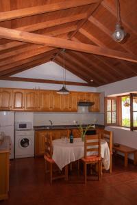 a kitchen with a table and chairs and wooden cabinets at Casa Rural Nuevitas I in Hermigua