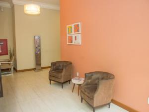 a waiting room with two chairs and a table at Hotel Rede 1 in Campos dos Goytacazes