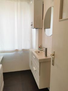 een witte badkamer met een wastafel en een bad bij Au fil de l eau in Namen