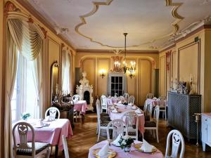 un ristorante con tavoli e sedie rosa e un soffitto di Hotel zum Schwan a Bad Karlshafen