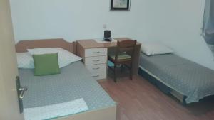 1 dormitorio con 2 camas, escritorio y silla en Apartments Zemunik en Omiš