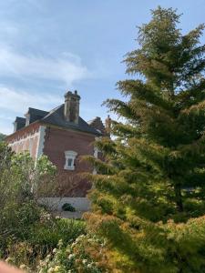 un gran edificio de ladrillo con un árbol delante de él en Chambres d'Hôtes Villa Mon Repos en Saint-Aubin-sur-Scie