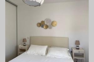 1 dormitorio con 1 cama blanca, 2 mesas y reloj en FUNTANA NOVA en Piana