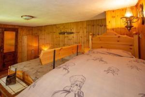 1 dormitorio con 1 cama en una habitación con paredes de madera en StudiÒ Melignon, en Rhemes-Saint-Georges