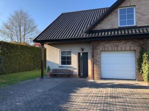 a garage with a bench in front of a house at Morskie Zacisze Karwia in Karwia