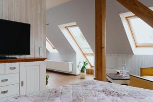 een slaapkamer met een bed en een tv op zolder bij Hotel An den Bleichen in Stralsund