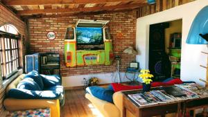 a living room with a couch and a tv at SPACE 4 U - HOTEL BOUTIQUE TEM&Aacute;TICO - Aeroporto in S&atilde;o Jos&eacute; dos Pinhais
