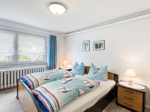 ein Schlafzimmer mit einem Bett mit blauen Kissen in der Unterkunft Comfortable Apartment in Wismar near the Baltic Sea in Wismar