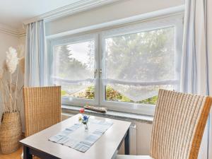 ein Esszimmer mit einem Tisch, 2 Stühlen und einem Fenster in der Unterkunft Comfortable Apartment in Wismar near the Baltic Sea in Wismar