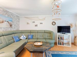 a living room with a green couch and a table at Comfortable Apartment in Wismar near the Baltic Sea in Wismar