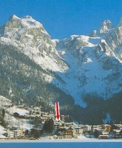 a snow covered mountain with a city in front of it at Appartamenti Katinanna in Alleghe