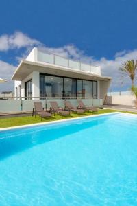 uma casa com piscina em frente a uma casa em Villas Mariposas Dreams em Corralejo