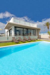 a house with a swimming pool in front of a house at Villas Mariposas Dreams in Corralejo