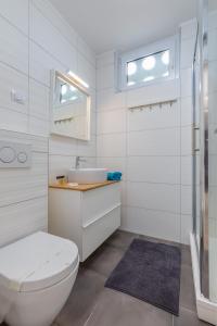 a white bathroom with a toilet and a sink at FantaSEA apartment in Fažana