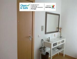 uma casa de banho com um lavatório, um espelho e uma porta em Portela - APARTAMENTO em Viana do Castelo