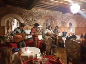eine Gruppe von Leuten, die in einem Restaurant Musik spielen in der Unterkunft Chateau La Tour Du Roy in Vervins