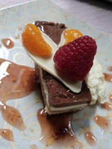 a piece of chocolate dessert with fruit on a plate at Chateau La Tour Du Roy in Vervins