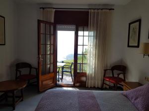 1 dormitorio con 1 cama y puerta a un balcón en Hostal Sa Barraca - Adults Only, en Begur