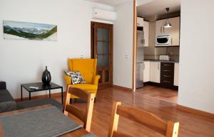 a living room with a table and chairs and a kitchen at Apartamento Cactus Centro in Úbeda