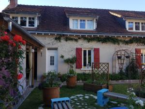 a white house with red doors and a yard at Ideal pour une pause in Saint-Georges-sur-Cher