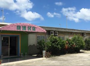 a building with a sign on the front of it at Kenting Airport Homestay 機場民宿 in Hengchun South Gate