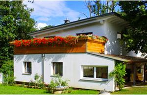 a white house with red flowers on the roof at Charming house in Purgstall with a private garden in Hart