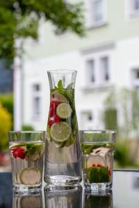 dwie szklanki wody i wazon wypełniony owocami w obiekcie Holiday Apartments Wettin w mieście Bad Schandau