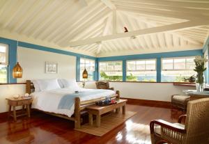 a bedroom with a large bed with blue walls and windows at Lake Vilas Charm Hotel in Amparo