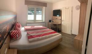 a bedroom with a bed and a desk and a television at Abtei Apartment Brauweiler in Pulheim +6 photos