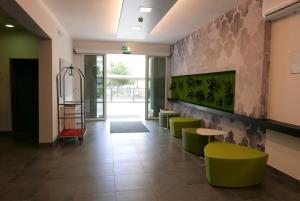 un vestíbulo de un hospital con sillas y mesas verdes en Hotel Nederland, en Caorle