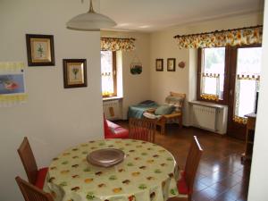 a dining room with a table and a table and chairs at Appartamenti Katinanna in Alleghe